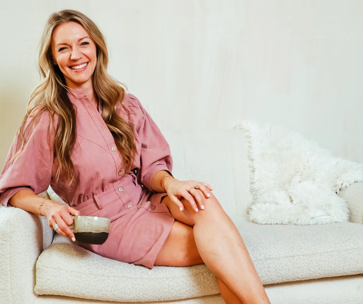 A woman sitting on top of a white couch.